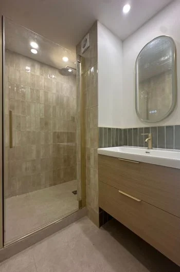 Salle de bain rénovée à La Grande Motte dans des matériaux naturels, avec des touches de doré