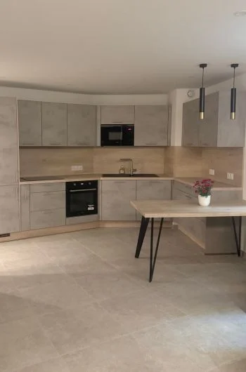 Cuisine et salle à manger rénovée à La Grande Motte dans des tons gris clair et des matériaux bruts